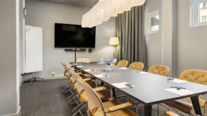 konferensrum med beiga stolar och trä bord med tv på väggen